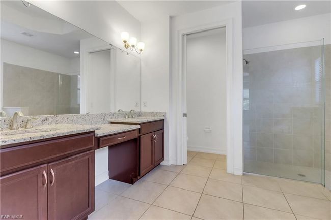 Bathroom with a tile shower, tile patterned flooring, double vanity, toilet, and recessed lighting | Image 15