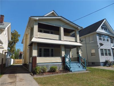 View of front of property with a balcony, covered porch, and a front lawn | Image 1