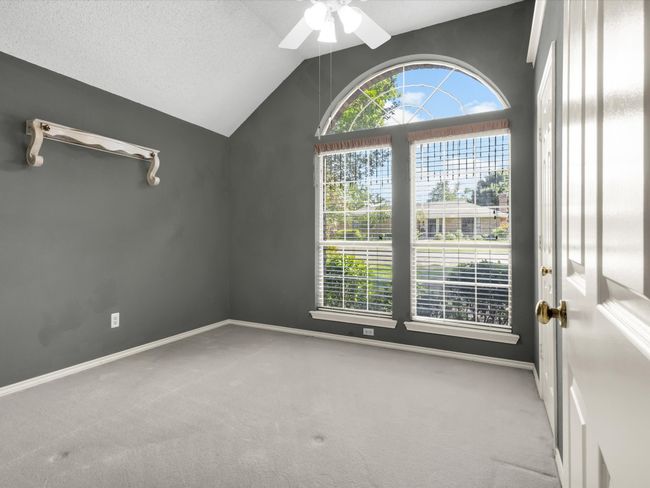 Secondary bedroom located at front of home features large arched windows for lots of natural light as well as a walk-in closet. | Image 30