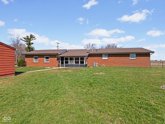 rear view of house featuring brick siding, a sunroom, and a yard | Image 30