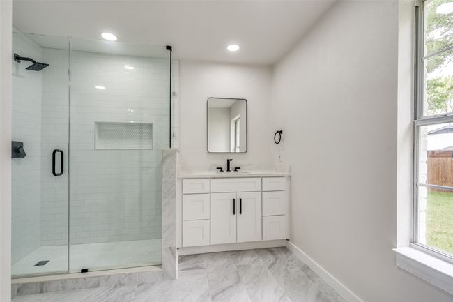 Full bath featuring marble look tile flooring, vanity, a shower stall, and recessed lighting | Image 17
