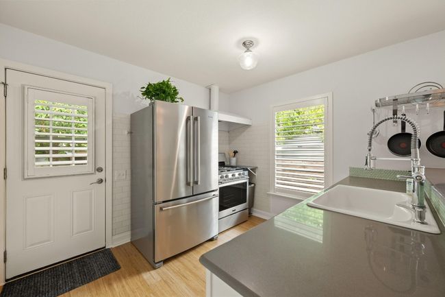 The kitchen features neutral quartz counters. | Image 8