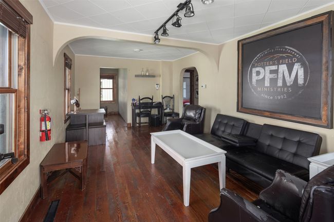 Living area with crown molding, track lighting, visible vents, arched walkways, and hardwood / wood-style flooring | Image 12