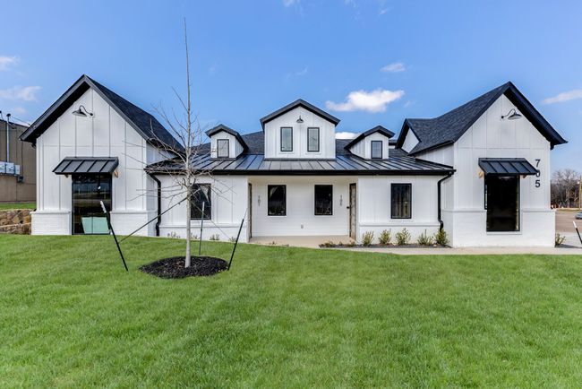 Rear view of house with a standing seam roof, board and batten siding, a lawn, a metal roof, and a shingled roof | Image 21