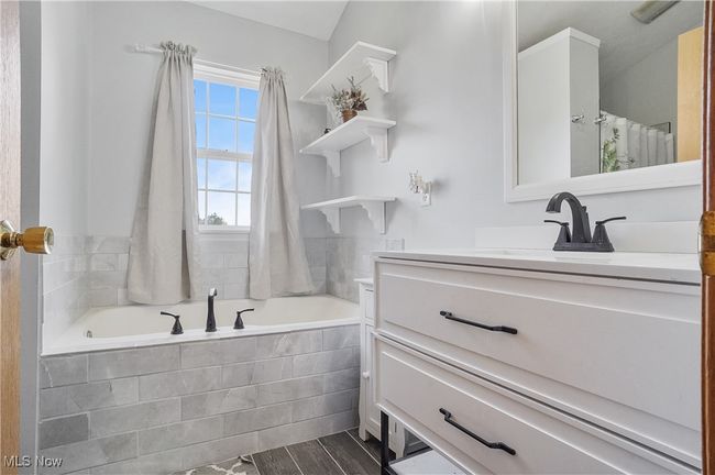 Full bathroom with wood finished floors, a bath, and vanity | Image 29