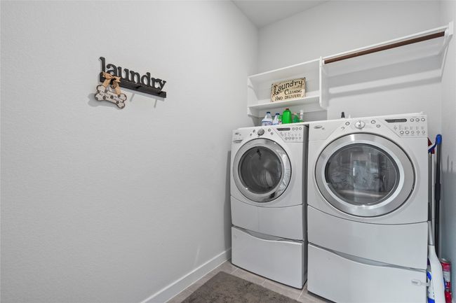 Laundry area featuring independent washer and dryer, baseboards, and tile patterned floors | Image 25