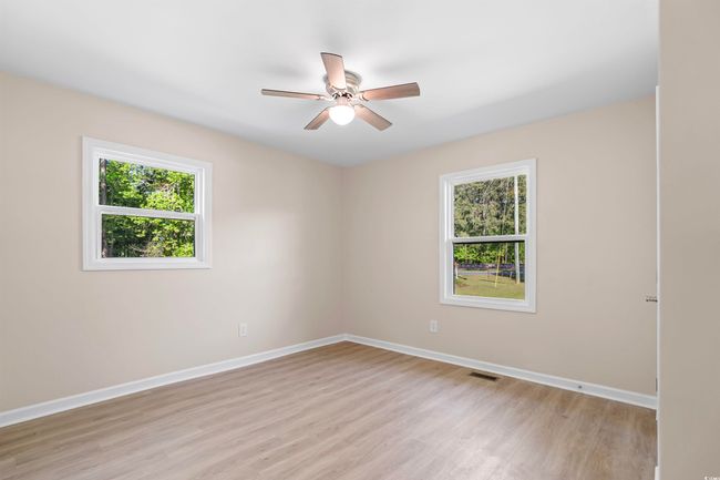 Unfurnished room with plenty of natural light, light wood-style flooring, and a ceiling fan | Image 26