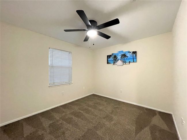 Spare room featuring dark colored carpet and a ceiling fan | Image 21