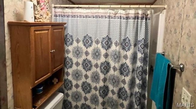 Full bathroom featuring toilet and curtained shower | Image 5