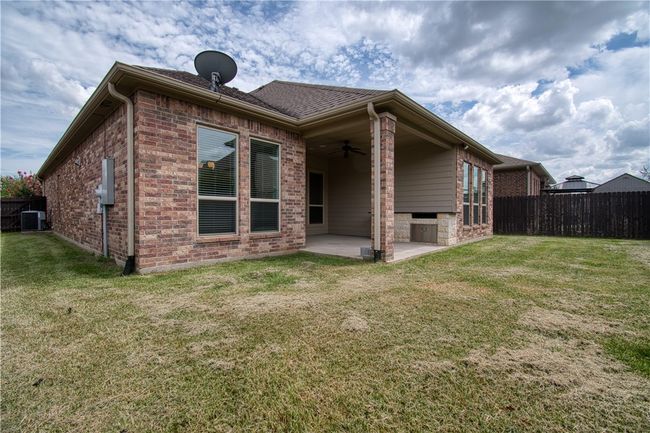 Back of property featuring a fenced backyard, a lawn, a patio area, and a ceiling fan | Image 23