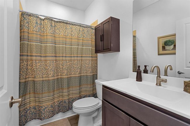 Crisp and clean with modern finishes, this full bath is easily accessible from the secondary bedrooms. | Image 33