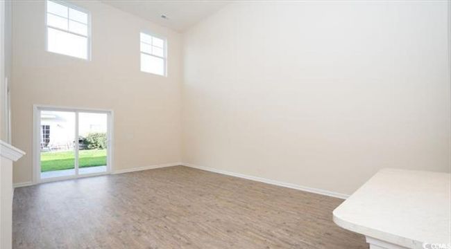 Unfurnished room with a wealth of natural light, baseboards, a high ceiling, and wood finished floors | Image 13