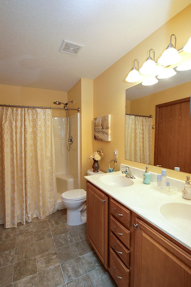 Primary ensuite bathroom features a double sink and a walk-in shower. | Image 8