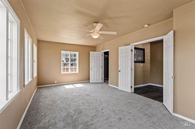 Unfurnished bedroom with a walk in closet, carpet floors, and ceiling fan | Image 22