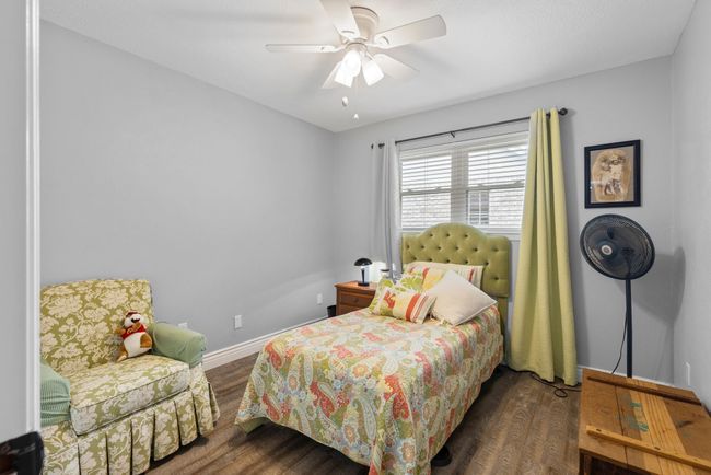 Bedroom with wood finished floors and ceiling fan | Image 16