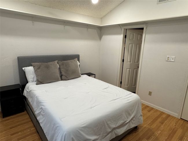 Bedroom with wood finished floors and vaulted ceiling | Image 14