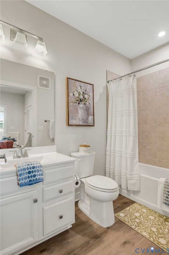 Bathroom with wood finished floors, vanity, and shower / tub combo | Image 11