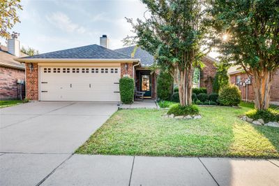 Ranch-style home featuring a front lawn and a garage | Image 1