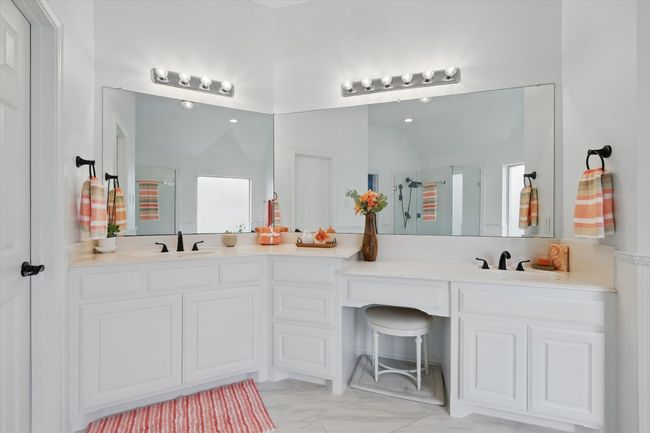 Dual his & hers sinks with seated vanity space. | Image 22