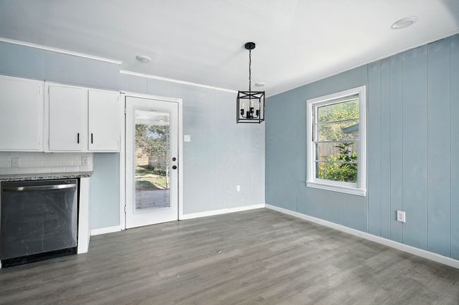 Unfurnished dining area with crown molding, wood finished floors, and a chandelier | Image 11