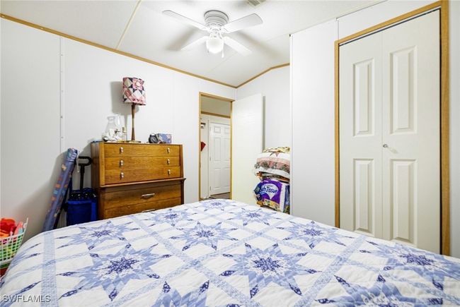 Guest bedroom with lofted ceiling, ornamental molding, and ceiling fan | Image 15