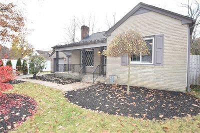 Distinctive stone front and landscaping! Large front porch overlooks wooded park area directly across the street. | Image 2