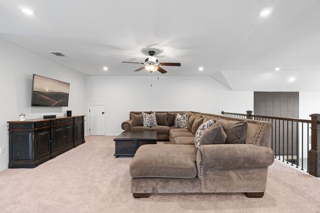A roomy upstairs loft with recessed lighting, a ceiling fan, and carpet flooring. | Image 25