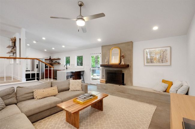 Living area featuring recessed lighting, a ceiling fan, stairs, a large fireplace, and vaulted ceiling | Image 4