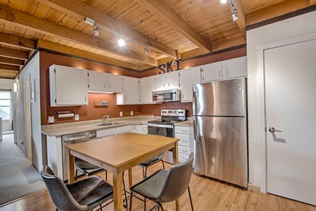 Kitchen featuring appliances with stainless steel finishes, rail lighting, wood ceiling, beamed ceiling, and light countertops | Image 6