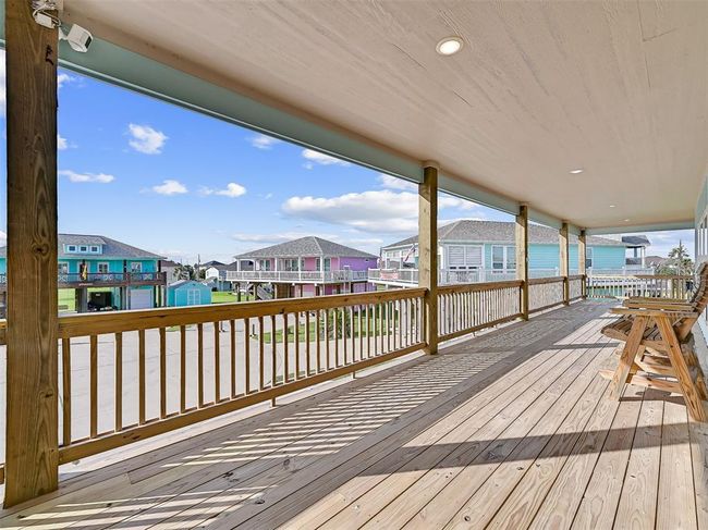 Split staircase leads to an expansive wrap-around deck—perfect for relaxing with views of the surrounding beachside community and catching the coastal breeze. | Image 4