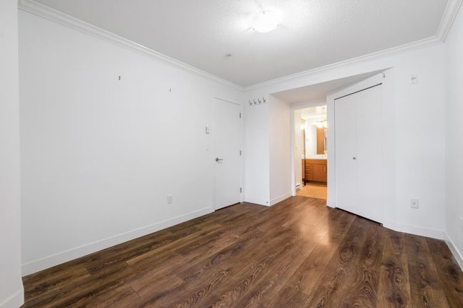 Unfurnished bedroom featuring ornamental molding, dark wood-style flooring, and connected bathroom | Image 18