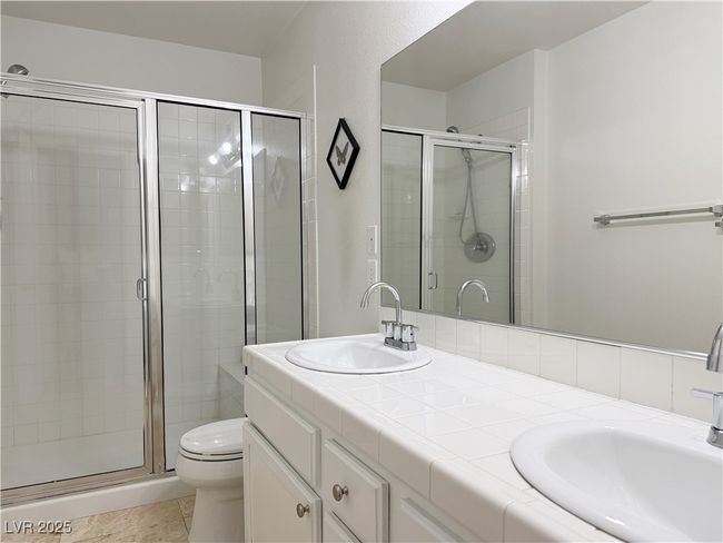 Bathroom with toilet, a sink, double vanity, and a stall shower | Image 33