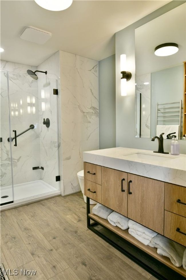 Bathroom featuring a marble finish shower, toilet, vanity, and wood finished floors | Image 28
