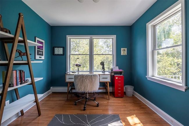 Office featuring a baseboard heating unit, plenty of natural light, and hardwood / wood-style floors | Image 11