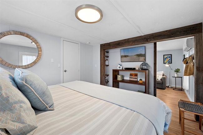Bedroom featuring light wood finished floors and a wall unit AC | Image 6
