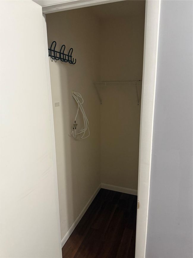 Walk in closet featuring dark wood-style floors | Image 15