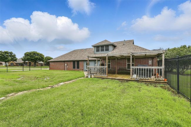 Back of property featuring a wooden deck, brick siding, a fenced backyard, and a shingled roof | Image 32