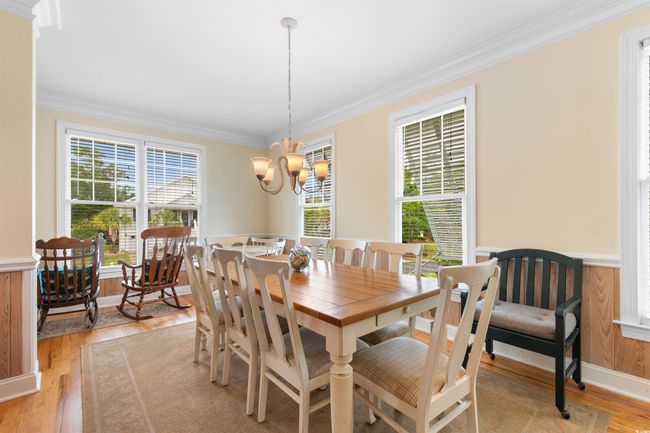 Dining room with ornamental molding, light wood-type flooring, a chandelier, and wainscoting | Image 9