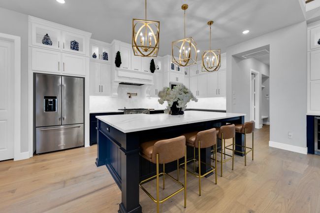 Kitchen with high quality fridge, a chandelier, recessed lighting, light wood-style flooring, and white cabinetry | Image 19
