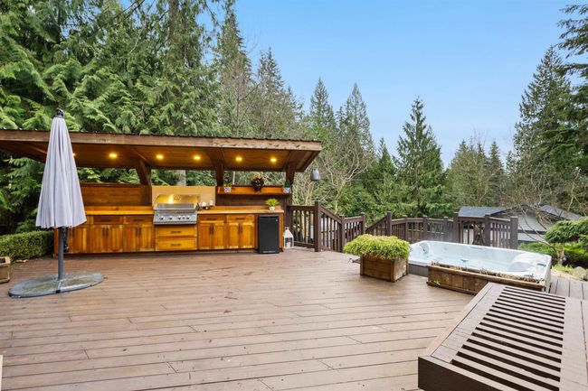 Deck featuring exterior kitchen and a grill | Image 32