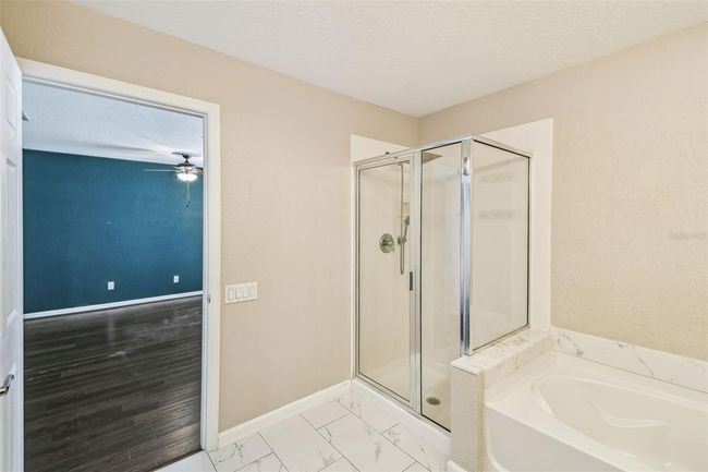 Upstairs primary bedroom features an en-suite, updated bathroom complete with a double vanity, garden tub, walk-in shower, and a private toilet closet. | Image 17