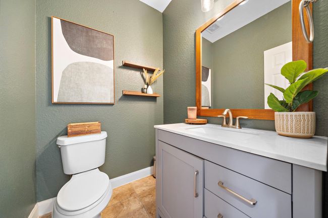 This elegantly appointed half bath features an exquisite vanity and contemporary fixtures. Thoughtful design elements like open shelving and stylish wall decor enhance the space, creating a refined yet welcoming atmosphere that blends functionality with aesthetic appeal seamlessly. | Image 28