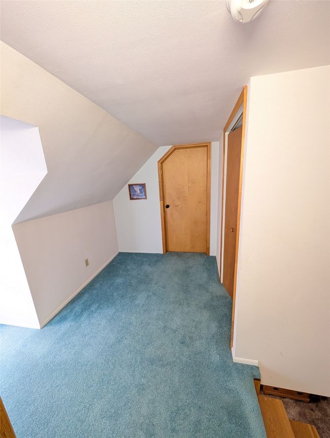 Additional living space featuring lofted ceiling and dark carpet | Image 14