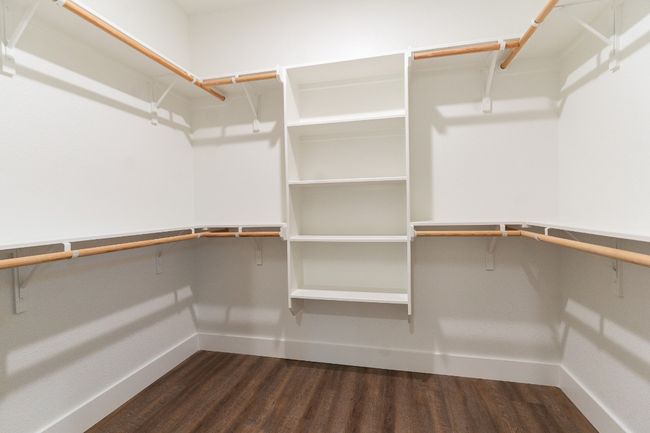 Spacious closet with dark wood finished floors | Image 17