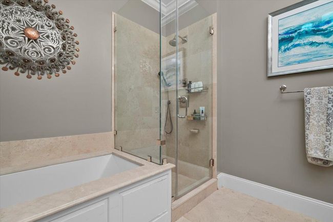 Bathroom with baseboards, tile patterned flooring, a stall shower, and a bath | Image 15