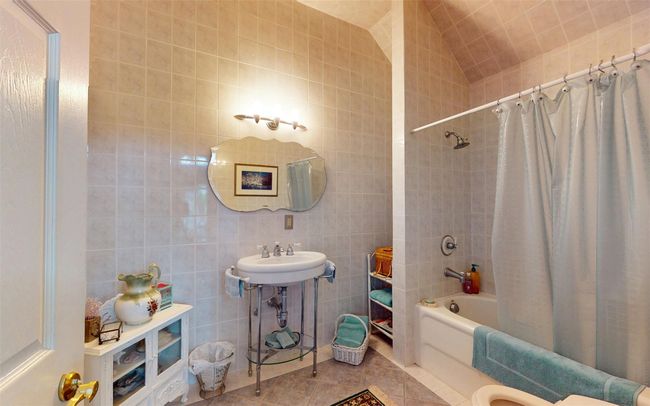 Bathroom with tile walls, shower / bath combo, and tile patterned flooring | Image 31