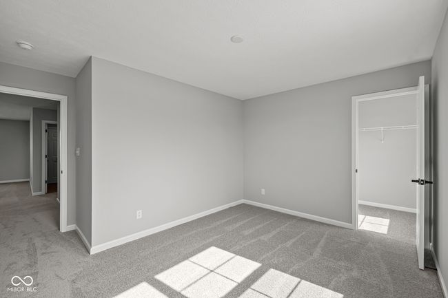 unfurnished bedroom featuring baseboards, carpet flooring, a closet, and a spacious closet | Image 12