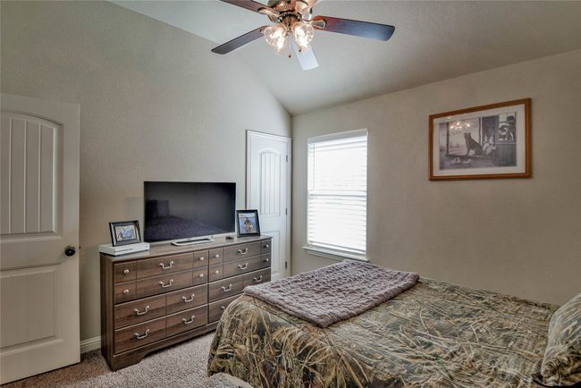 Bedroom with carpet floors, baseboards, a ceiling fan, and lofted ceiling | Image 24