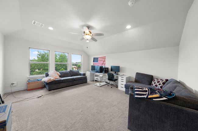 Living area with carpet floors, lofted ceiling, ceiling fan, a desk, and recessed lighting | Image 15