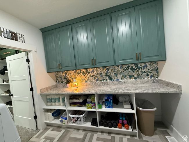 Interior space with green cabinetry, open shelves, and tasteful backsplash | Image 46